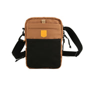 Small brown and black crossbody bag with a front pocket and adjustable black strap.