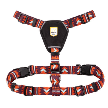 Red and black patterned dog harness with adjustable straps and a black chest pad displaying the Woolly Wolf logo.