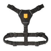 Black dog harness with a yellow logo patch and adjustable straps.